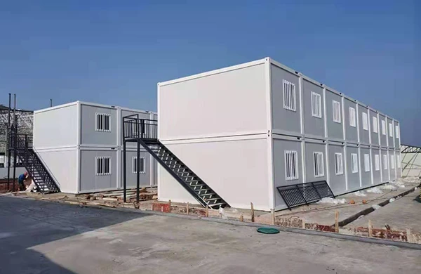 Varias casas de contenedores de paquete plano se apilan en el sitio de construcción