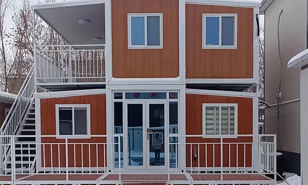 A two-story 20' expandable container house is placed beside of the brick house.